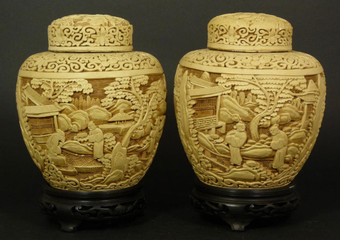 PAIR OF CHINESE WHITE CINNABAR GINGER JARS: A pair of Chinese white cinnabar covered ginger jars. Each having relief palace garden landscape scenes to body and cover. Lotus blossom and scrolled vines adorn neck. Late Qing to early Republic peri