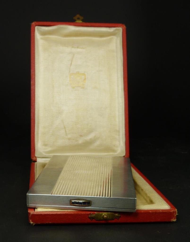 CARTIER STERLING SILVER & SAPPHIRE CIGARETTE CASE: Vintage Cartier sterling silver cigarette case having a hinged design. Box has a horizontal and vertical pinstripe line design. Holds impressed French silver purity marks. Clasp holds 5 emerald cut sa