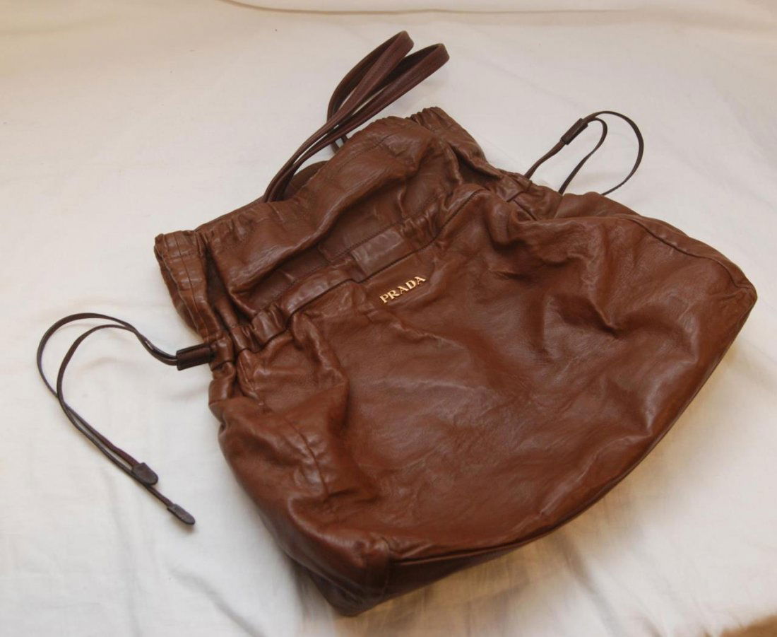 PRADA BROWN LEATHER PURSE: Prada brown leather purse. Black silk PRADA interior. One zippered pocket to interior. Measures 15" height x 14" width (38.1cm x 35.5cm).