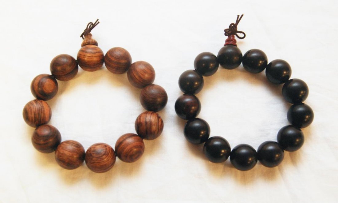 CHINESE WOODEN BEADED BRACELETS HUANGHUALI & ZITAN: A lot of two Chinese wooden beaded bracelets including one Huanghuali and one Zitan. Each bead nicely polished. Each bead approx. 19mm. Unstretched, the bracelets measure approx. 3 3/4" diameter (9.5c