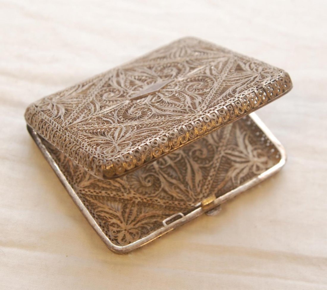 EUROPEAN SILVER FILIGREE CIGARETTE BOX: European silver cigarette box with beautiful intricate filigree work throughout. Floral and scroll design, rectangular in shape. Measures 2 3/4" height (7 cm) height 2.6 ozt.
