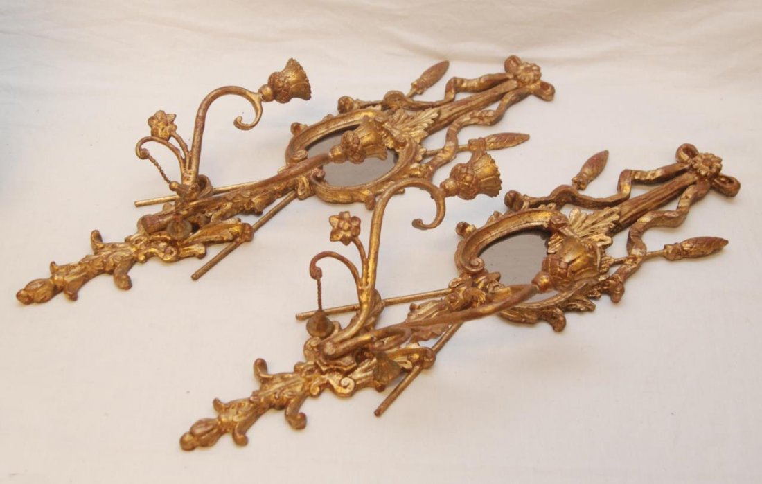 PAIR OF GILT WOOD MIRRORED WALL SCONCES: Pair of gilt wood mirrored wall sconces. Each holds two small candles and measures approx. 23"(58 cm) length. Provenance: From the Estate of Count and Countess Claes-Eric de Lewenhaupt of Sweden.