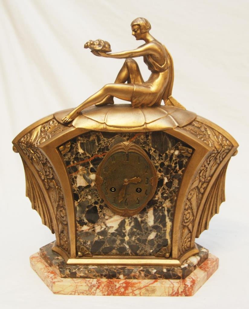 FRENCH ART DECO LIMOUSIN GILDED BRONZE CLOCK: Old French Art Deco mechanical clock having a leaf design throughout. A woman is seated to top holding a fruit basket. Has marble front and base design. Movement marked 81586. Circa late 19th century 
