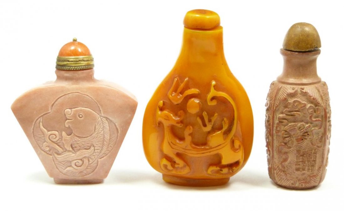 LOT OF THREE MISC. CHINESE SNUFF BOTTLES: Comprising of an orange one with a carved foo dragon that measures 3" (7.5 cm), a peach color hard stone one that has a floral design on one side and a carved fish on the other that measures 2 1/2" (6