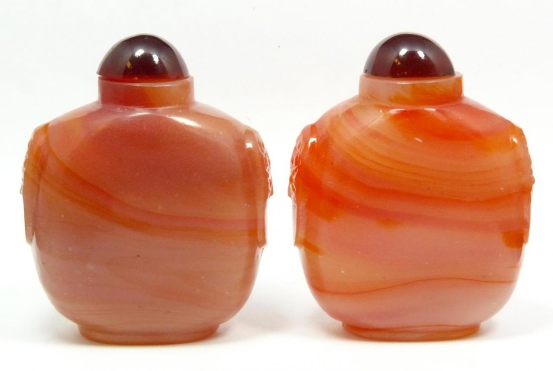 PAIR OF CARNELIAN SNUFF BOTTLES: Red incolor with cherry red tops. With cerry red tops. Measures 3 1/4" (8 cm) height. 305.3 grams.