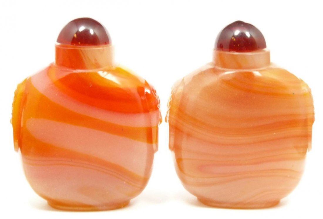 PAIR OF CARNELIAN SNUFF BOTTLES: Red incolor with cherry red tops. With cerry red tops. Measures 3 1/4" (8 cm) height. 334.9 grams.