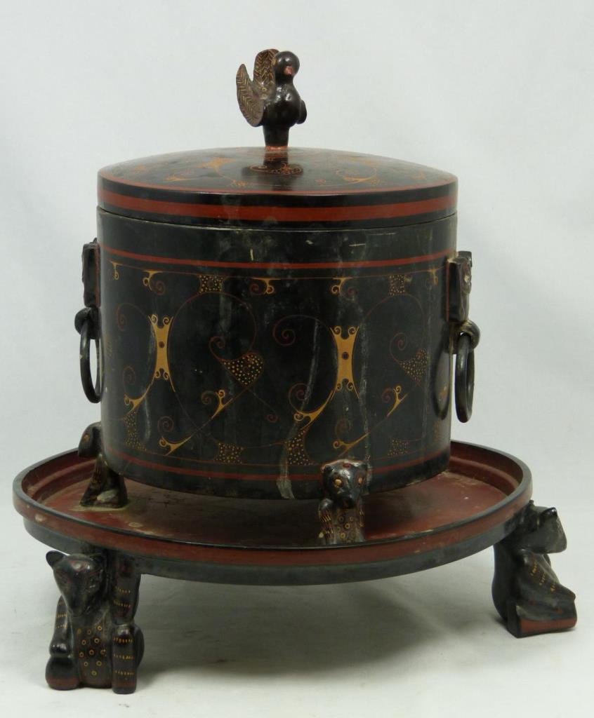 HAN DYNASTY BLACK AND RED LACQUER COVERED VESSEL: Chinese red and black lacquered covered Han Dynasty vessel. Figural bear tripod feet. Perched bird finial to cover. Measures 10 1/2" height x 11 1/2" diameter (26.6cm x 29.2cm).