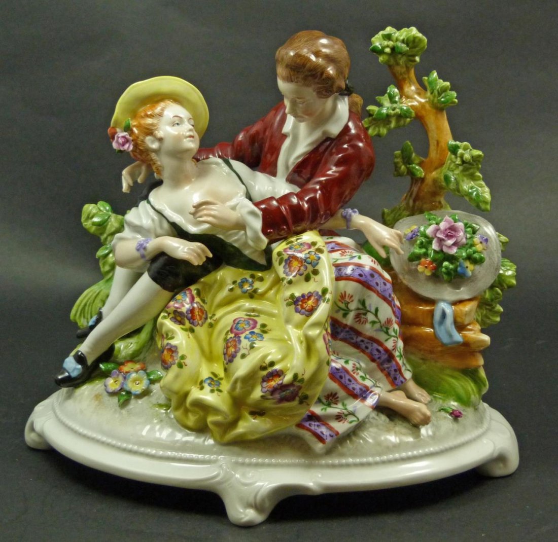 GERMAN PORCELAIN COURTING COUPLE SCULPTURE: Antique German hand painted porcelain group scene depicting a courting couple. Scrolled footed base. Blue crown over 'H U S' mark to bottom. First half of the 20th century. Measures 7 5/8" height x 9"
