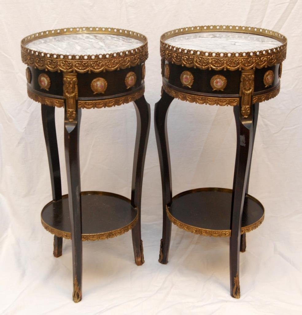 PAIR OF FRENCH MARBLE TOP SIDE TABLES WITH PLAQUES: A pair of French black painted wooden round end tables with black and white marble tops. Clad with gilded metal throughout and applied porcelain plaques depicting courting couples to sides. Early 20th