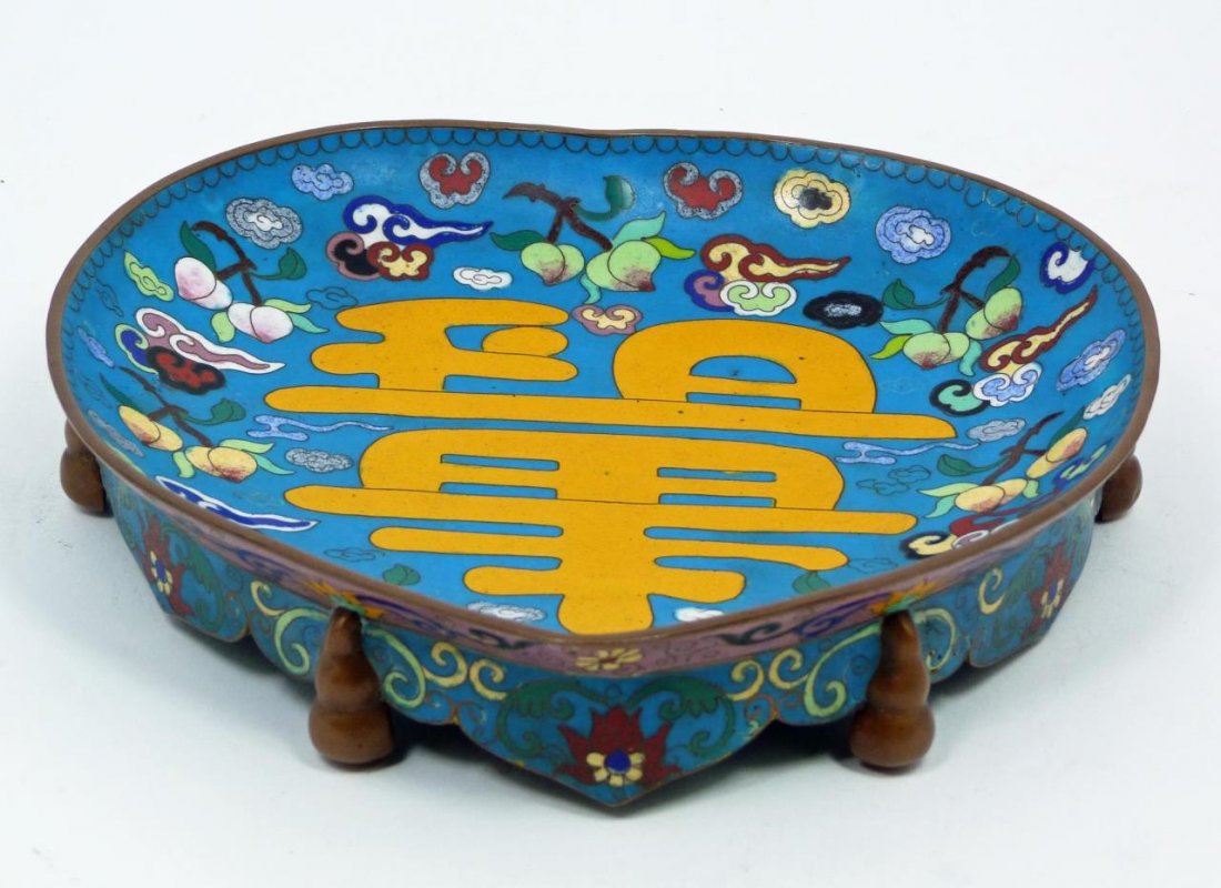 ANTIQUE CHINESE CLOISONNE FOOTED PEACH DISH: Antique Chinese hand painted enameled bronze peach form dish having a yellow calligraphy symbol to center. Peaches, clouds, and lingzhi can be seen surrounding the featured symbol. Six figural hulu do