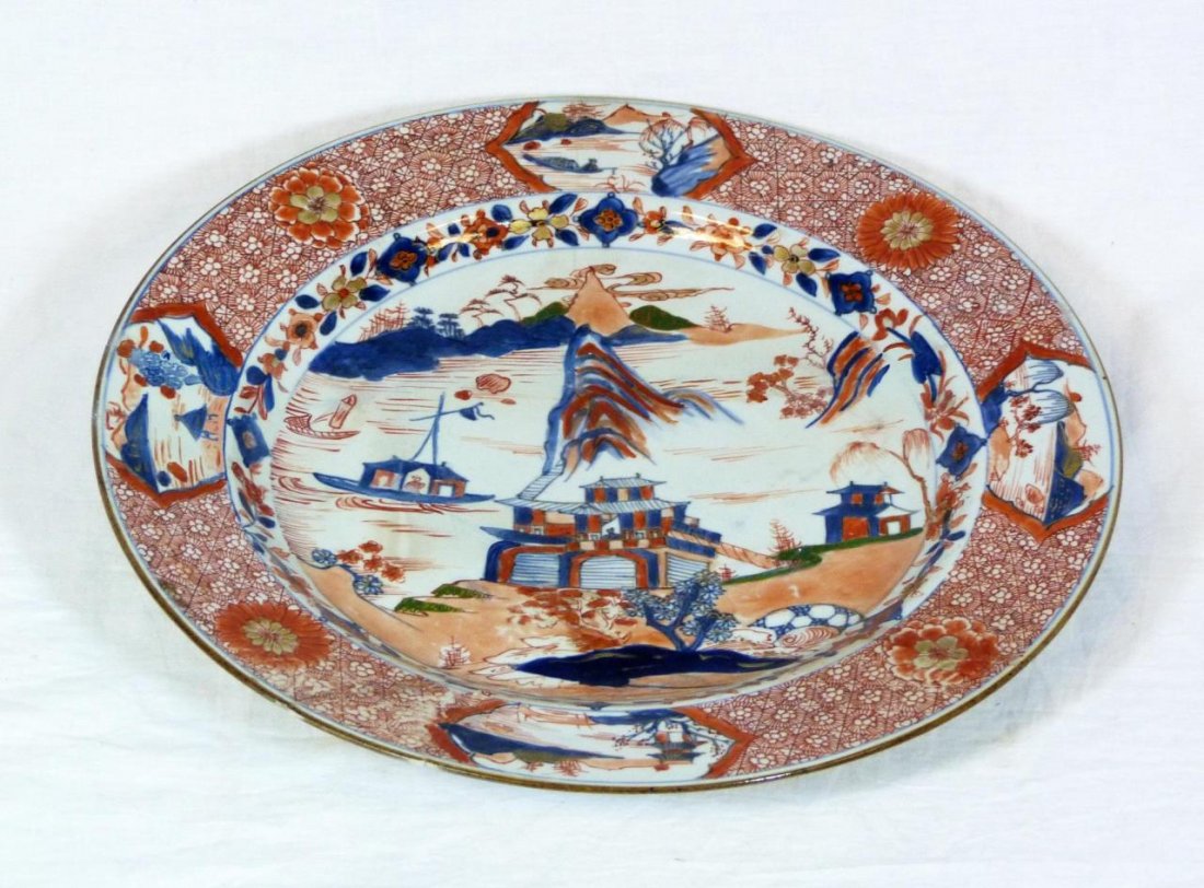 ANTIQUE CHINESE IMARI PORCELAIN CHARGER: Antique Chinese Imari hand painted iron red and blue charger depicting a coastal village scene. Late Edo to Meiji period, 19th century. Measures 13 7/8" diameter (13.8cm).