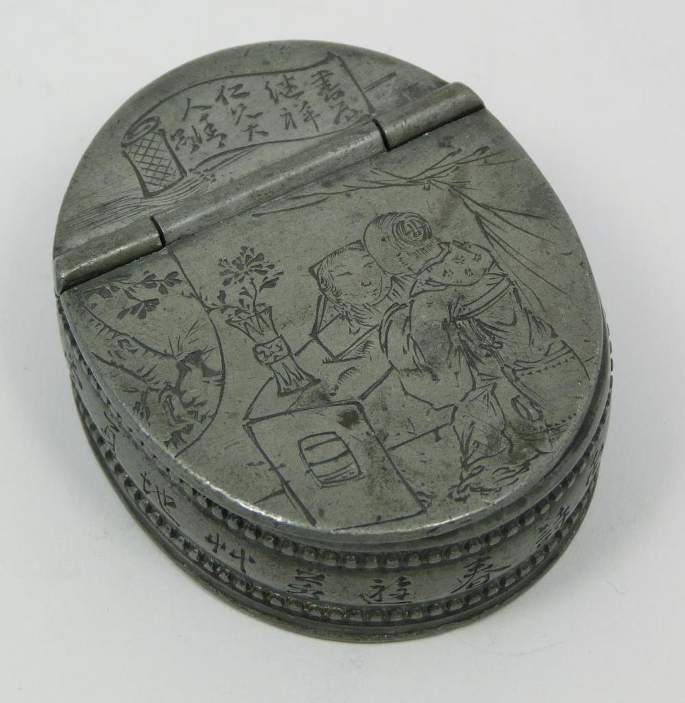 CHINESE ETCHED OVAL PILL BOX WITH CALLIGRAPHY: Antique Chinese etched pill box. Depicts two characters by a table with flowers in a vase. A poem is etched in Chinese on the inside with floral design. Has Chinese calligraphy marking on the bottom a