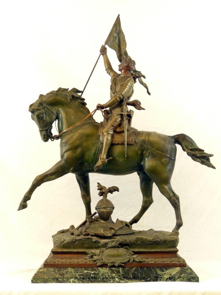 19th C FRENCH JOAN OF ARC SPELTER SCULPTURE: A large antique French spelter sculpture depicting Joan of Arc. Riding on her horse in full armor and carrying a flag with raised Fluer de Lis flowers. A plaque to front states 'JEANNE dArc A ORLEANS'