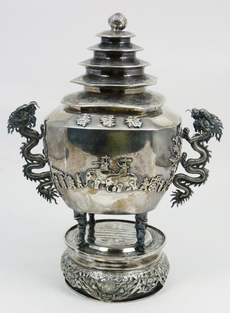 CHINESE STERLING SILVER COVERED DRAGONS URN: Chinese sterling silver lidded urn having figural dragon handles with applique caravan design to front and back depicting two noblemen on elephants with attendants leading and following them. Also has