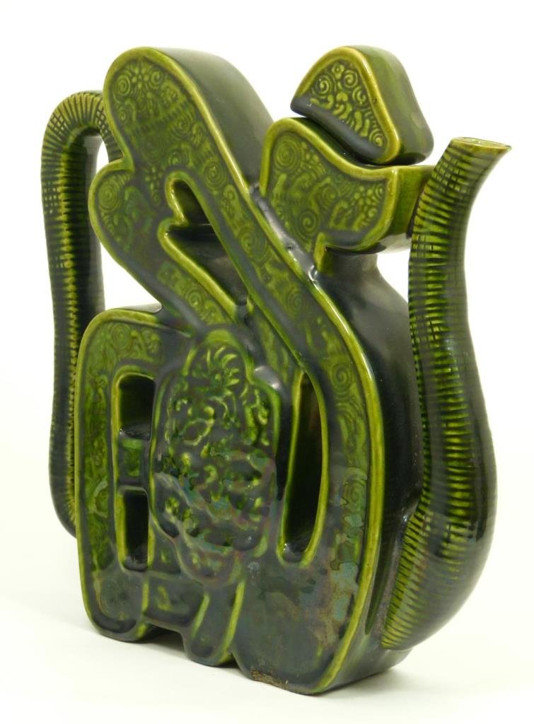 CHINESE GREEN GLAZED PUZZLE SHAPE TEAPOT: Chinese green glazed puzzle form teapot having raised dragons in lotus frame to center on front and back. Textured crashing waves design throughout. Circa late Qing to Republic period, 19th/20th centu