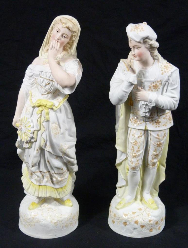 Pr ANTIQUE GERMAN PARIAN PORCELAIN SCULPTURES: A pair of antique German hand painted parian bisque porcelain sculptures depicting a man and woman with hand covering mouth. Each marked with '93.' Circa late 19th to early 20th century. Measures 16 3