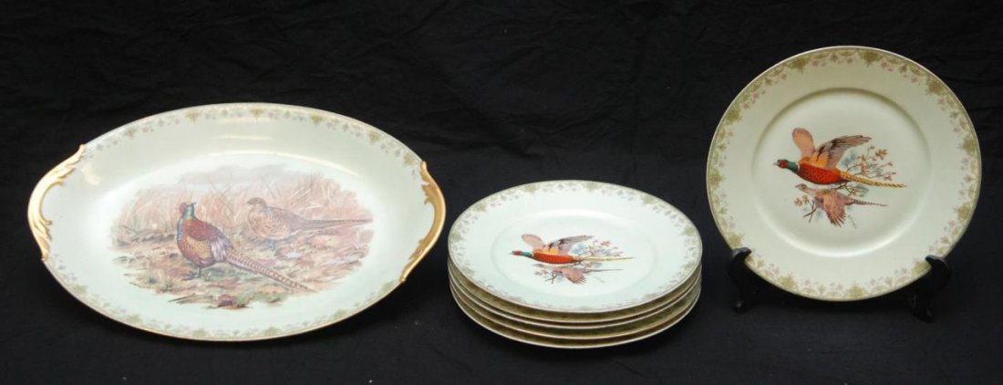 7 LIMOGES PORCELAIN GAME SCENE DINNERWARE PIECES: A lot of seven Limoges porcelain game bird scene dinnerware pieces including an oval serving platter and six dinner plates. Each piece having scrolled floral rim with hand painted center decoration ov
