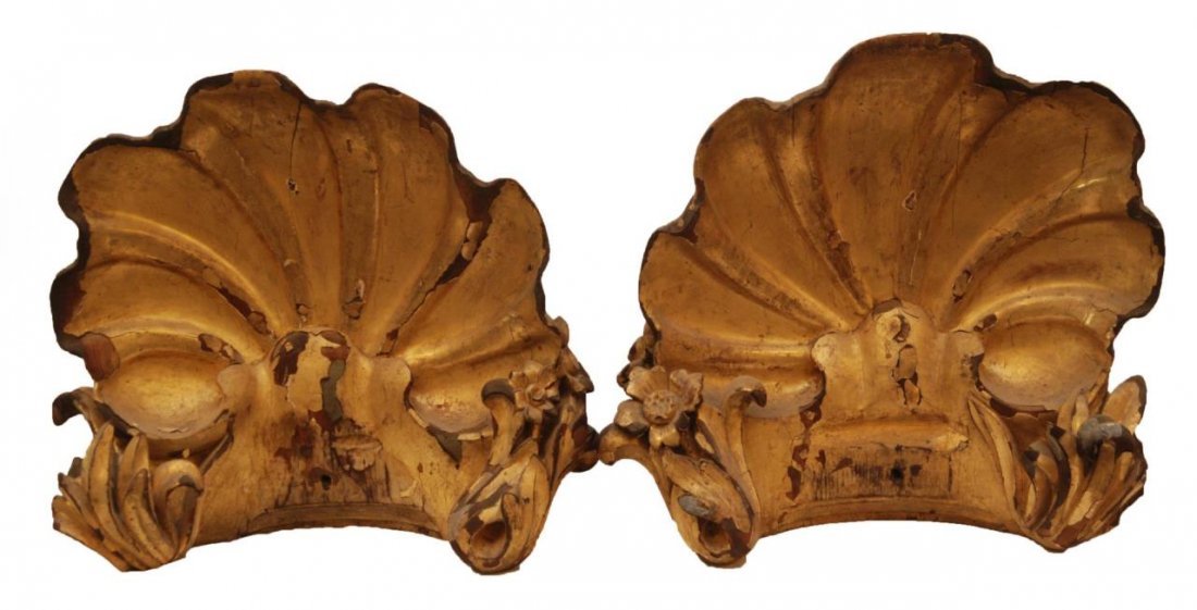 Pr CARVED GILT WOOD FIGURAL SHELL WALL BRACKETS: A pair of antique European hand carved and gilded wooden figural shell form wall brackets. Circa 19th century. Each measures approx. 15 1/4" height x 16" width (38.7cm x 40.6cm). Total weight of appro