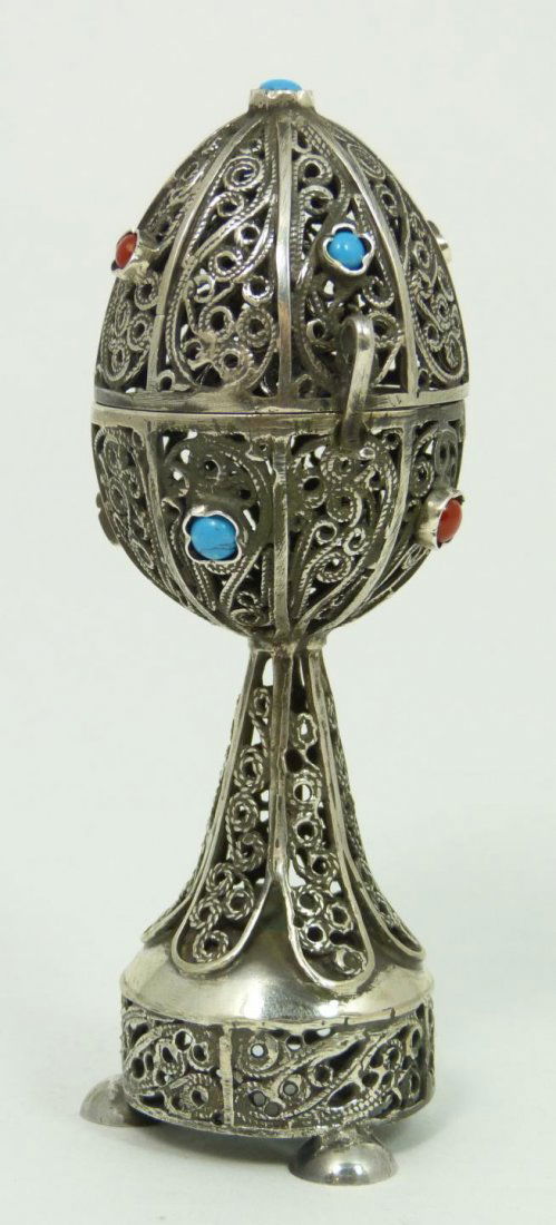 RUSSIAN SILVER JUDAIC FILIGREE SCENT BOX: A Russian filigree silver egg form scent box having a scrolled design throughout. Jeweled with turquoise and red coral. Has lion surprise inside egg. Holds 84 silver purity mark with town, maker and a