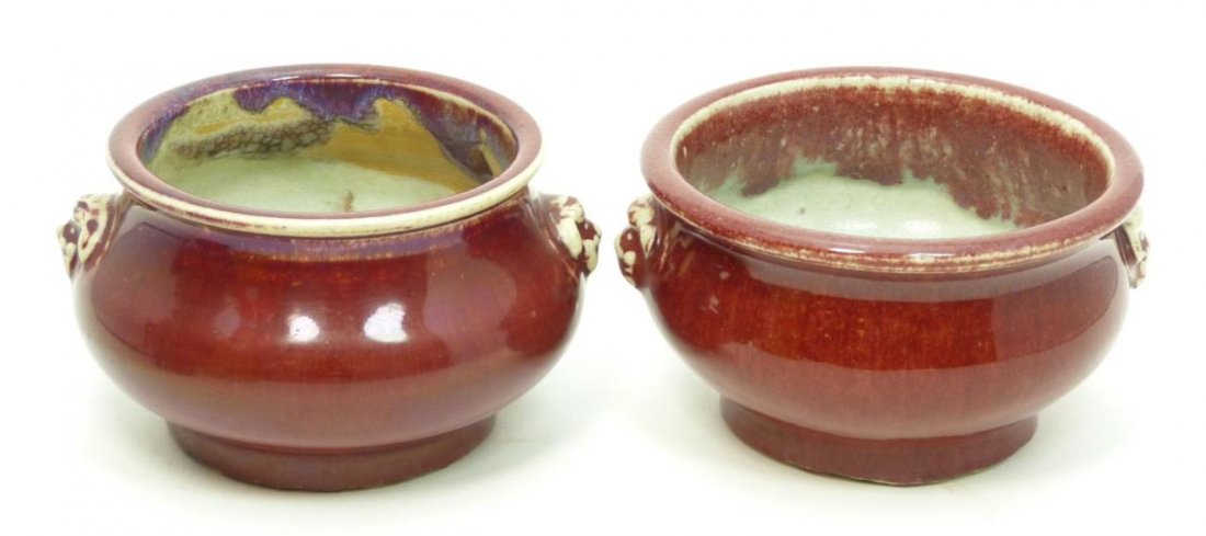 Pr MING DYNASTY OX BLOOD GLAZED DISHES: A pair of antique Chinese period ox blood glazed porcelain dishes having figural foo lion handles. Circa Ming Dynasty period (1368–1644). Each measures approx. 3 3/4" height x 5" diameter (9.5cm x 1