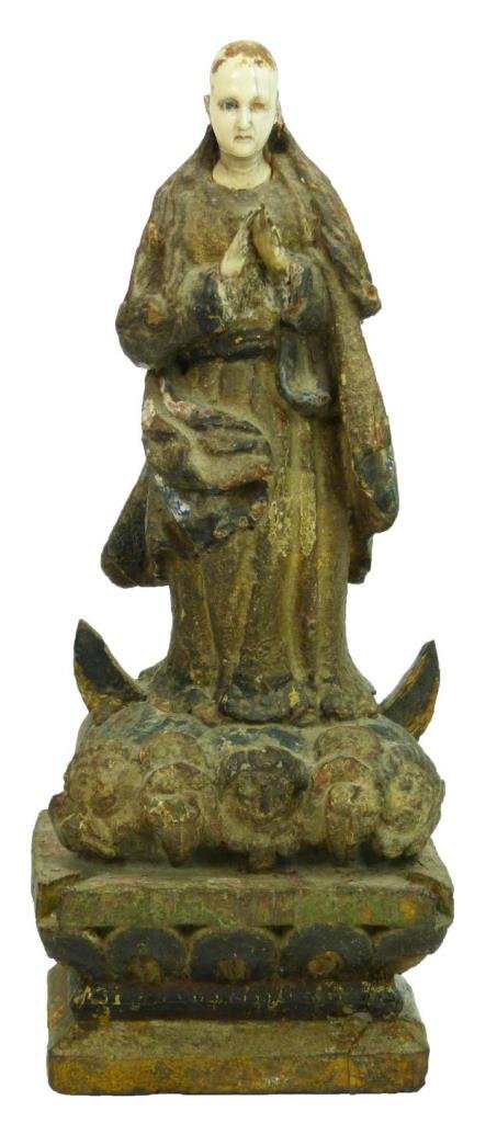 SPANISH COLONIAL CARVED GESSOED WOOD FIGURE: Antique Spanish Colonial hand carved, gessoed, and decorated figure depicting a standing religious figure atop three heads. Glass eyes set to face (one missing). Circa 18th/19th century. Measures 11 3