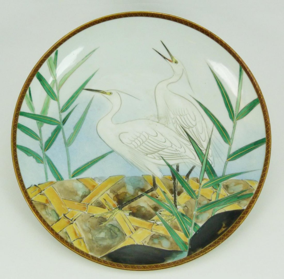 JAPANESE PORCELAIN CRANES SCENE CHARGER: A Japanese hand painted porcelain cranes scene charger. Each standing on earth with bamboo trees and leaves. Circa Edo to Meiji period, 19th/20th century. Measures 12 3/8" diameter (31.4cm). Total wei