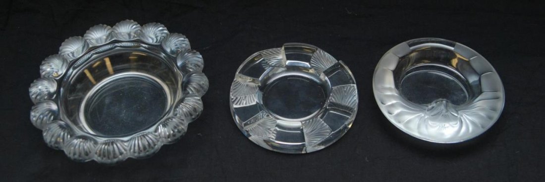 3 LALIQUE FRANCE CRYSTAL ASHTRAYS & BOWLS: A lot of three Lalique French crystal items including: a Tete de Lion ashtray, 'Cuba' ashtray and the 'Pornic' bowl. Each piece signed. Largest piece measures 2 1/4" height x 8" diameter (5.7cm x 20.3