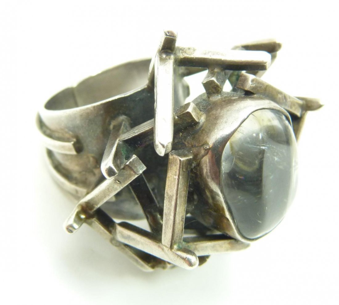 RACHEL GERA DESIGNER STERLING SILVER RING: Rachel Gera Israeli Designer sterling silver ring with a Brutalist design and holding center clear semi-precious stone. Inside of band marked 'HAND MADE GERA ISRAEL 925'. Ring size 8. Total weight of 
