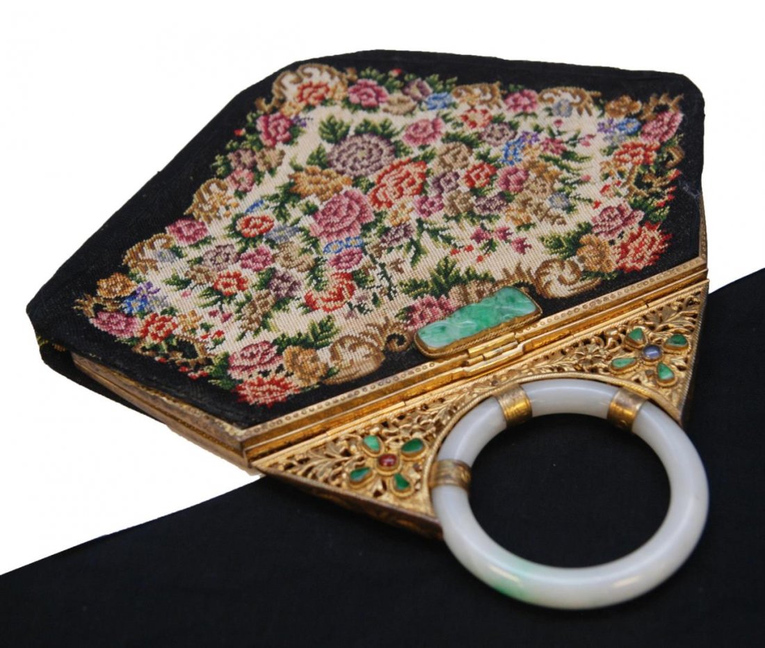 VINTAGE CHINESE RETICULATED JADEITE INLAID PURSE: A Chinese bangle handle handbag having choice white to apple green reticulated bangle handle and settings with ruby and opal. Silk interior with one open pocket. Includes leather wrapped fitted vanity