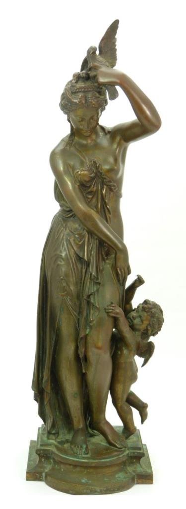 JEAN JACQUES PRADIER BRONZE SCULPTURE OF WOMAN: A Napoléon III bronze sculpture depicting a standing female in dress holding a dove above her head with left hand. To her left thigh is a winged cherub jumping for the bird. Signed 'Pradier' to base.