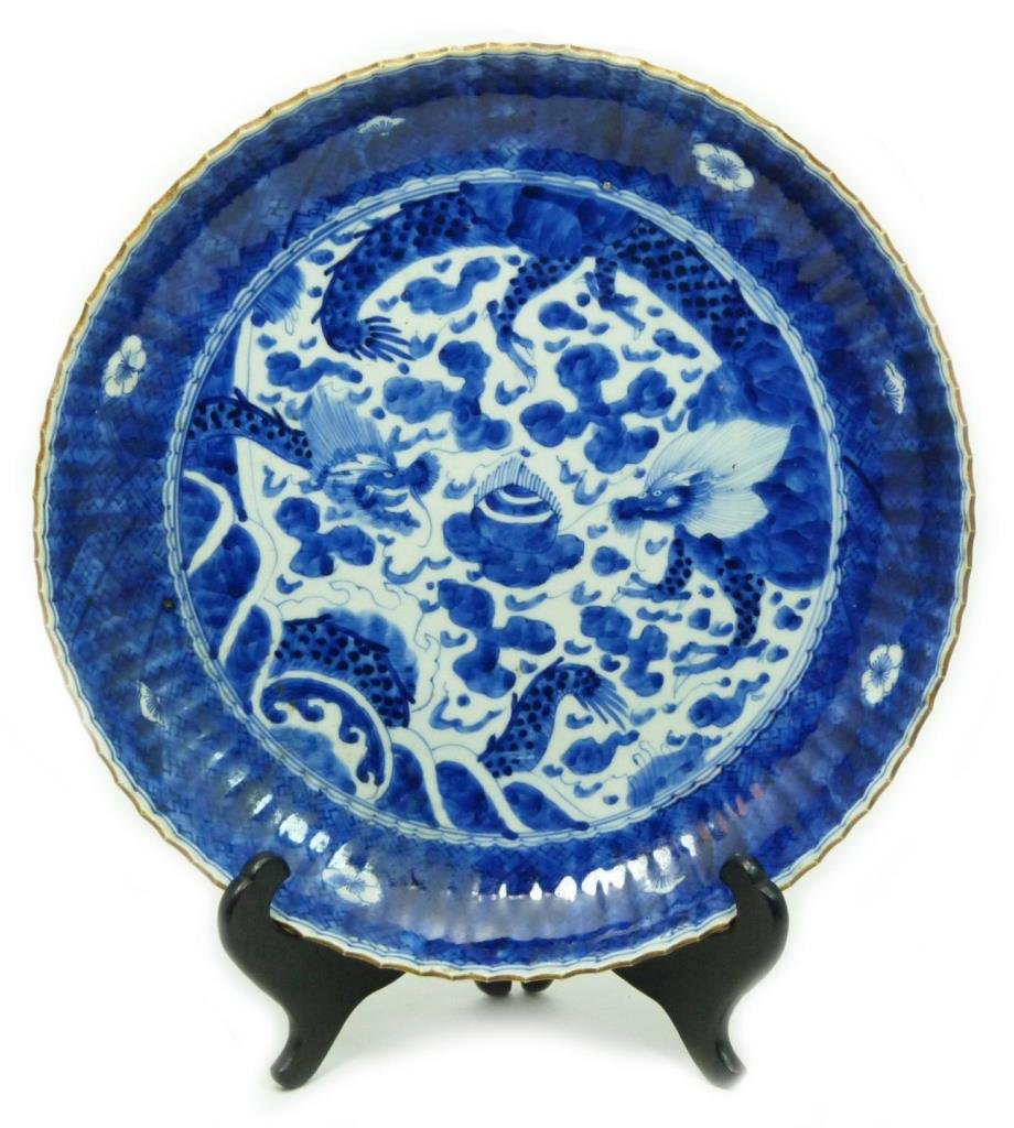 CHINESE BLUE & WHITE CHENGUA MARK DRAGON DISH: A Chinese Ming style blue and white hand painted porcelain bowl with dragon flying over water. Brown scalloped rim. Bottom holds blue six character Chenghua reign mark, but probably made in the Qing D
