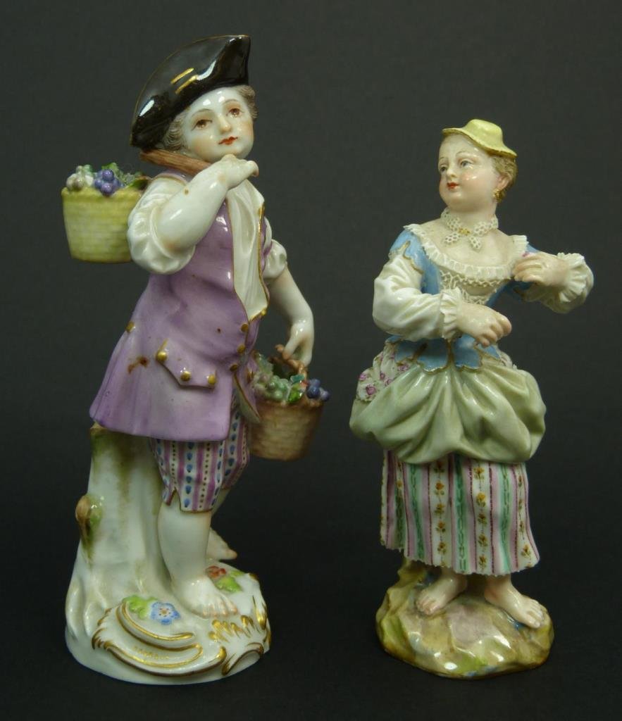 2 MEISSEN PORCELAIN SCULPTURES, A BOY AND GIRL: A lot of two antique Meissen hand painted German porcelain sculptures. Includes a barefoot boy carrying buckets of grape clusters, marked with impressed 93 to bottom, 5 7/8" height (14.9cm). Next is a