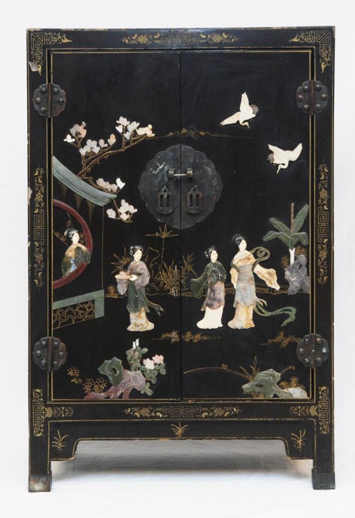 OLD CHINESE BLACK LACQUER STONE INLAID CABINET: An old Chinese hand crafted black lacquered wooden cabinet having a bone, jade, soapstone and hard stone inlay design to front double hinged doors depicting a palace garden scene with four maidens. Br