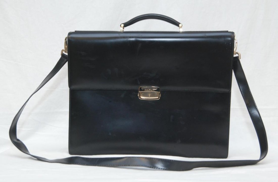 SALVATORE FERRAGAMO BLACK LEATHER ATTACHE CASE: A Salvatore Ferragamo Italian designer leather attache brief case with shoulder strap. Has two section divided interior with one zippered pocket. Label to interior numbered FB-245026. Gold tone hardwa