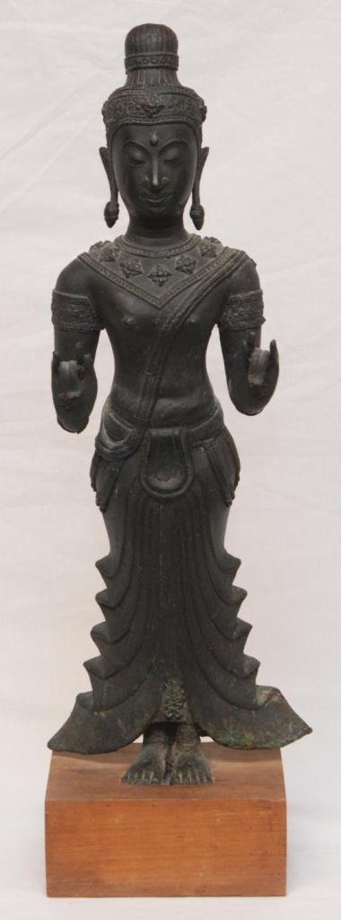 THAI BRONZE SCULPTURE OF STANDING BUDDHA: Antique Thai bronze sculpture depicting a standing Buddha. He is depicted with head dress and raised lotus blossom neck decoration. To each palm he is holding a lotus blossom. Includes fitted wooden b