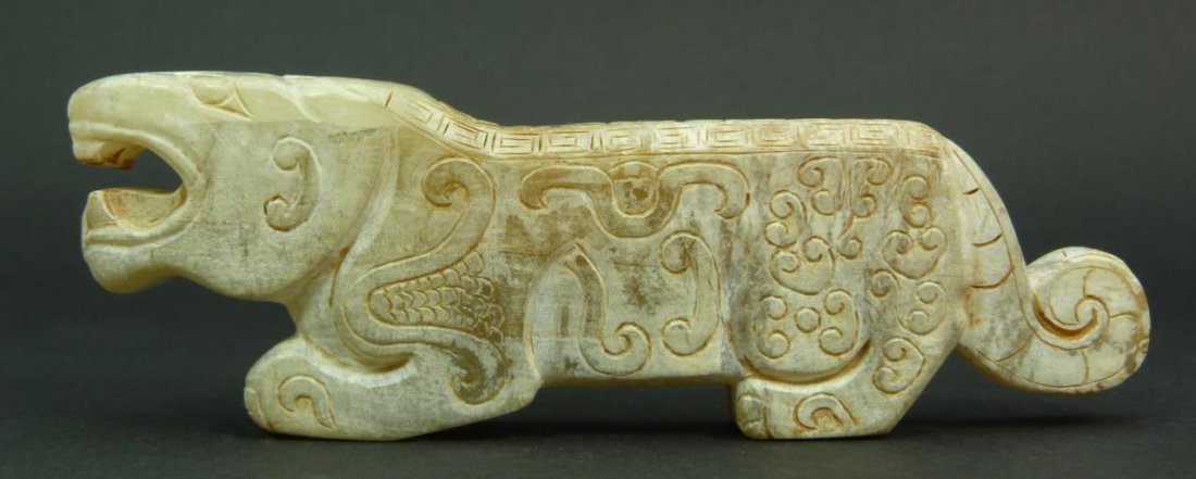 CHINESE HAN STYLE CARVED JADE BEAST TOGGLE: Chinese hand caved Han style carved jade Chih Lung Dragon toggle. The beast is depicted in a standing position. Measures 2" height x 5 1/2" length x 7/8" depth (5.1cm x 13.9cm x 2.2cm). Total weight o