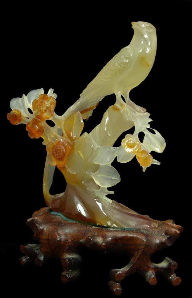 CHINESE CARVED CARNELIAN PARADISE BIRD CARVING: A Chinese carved carnelian stone sculpture depicting a perched bird of paradise. Includes fitted wooden base. Measures 4 5/8" height + 1" base height (11.7cm + 2.5cm). Total weight of 156 grams.