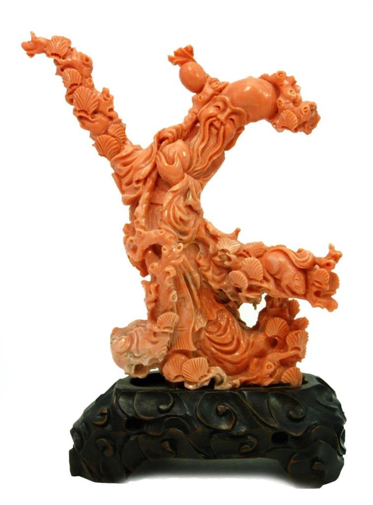 CHINESE CARVED CORAL SCULPTURE OF SHOU LOU: CHINESE CARVED CORAL SCULPTURE OF SHOU LOU Incredible antique red coral carved Shou Lou surrounded by seashells. Mid to late 19th century. Measures 6-1/2" tall (16.51cm) sits atop a footed wooden base