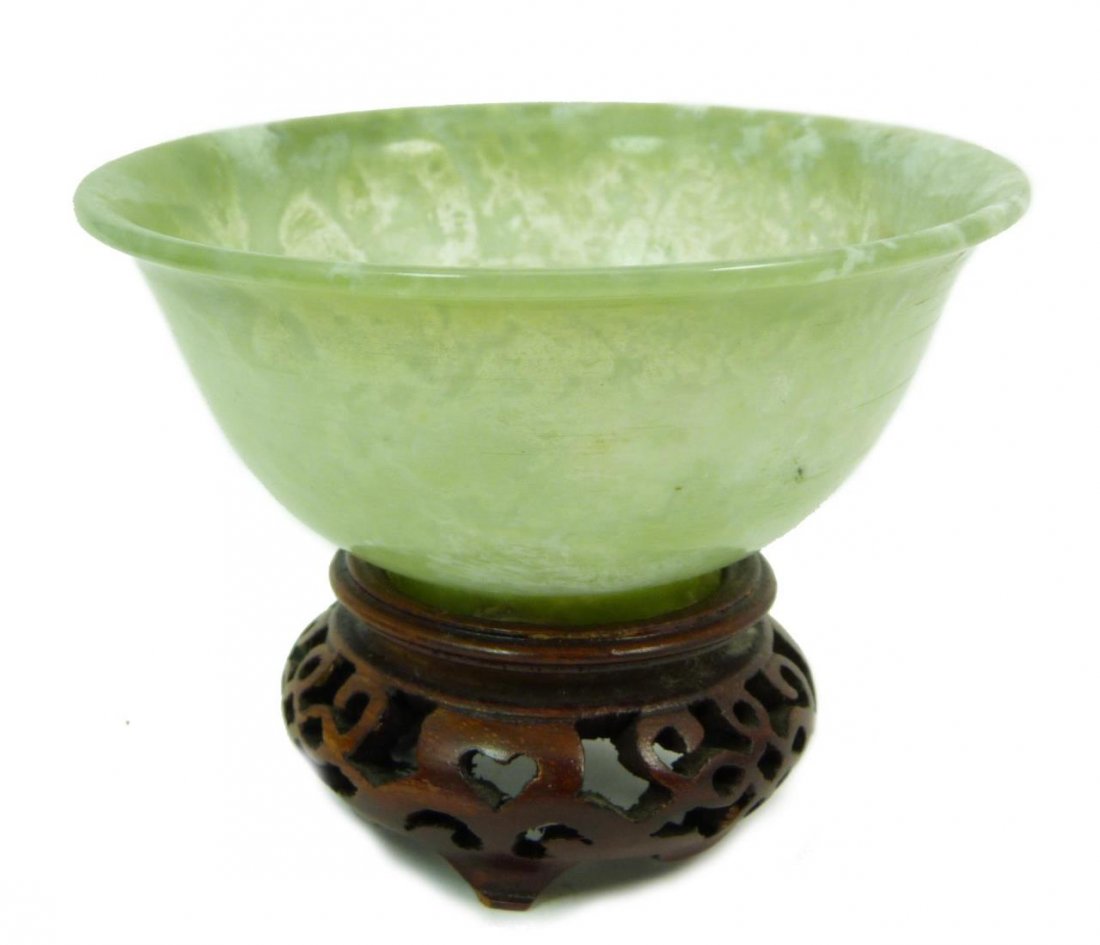 CARVED MUGHAL STYLE JADE BOWL: CARVED MUGHAL STYLE JADE BOWL Translucent early 20th century bowl. Measures 4" (10.16cm) in diameter comes in footed wooden base. Total weight 86g