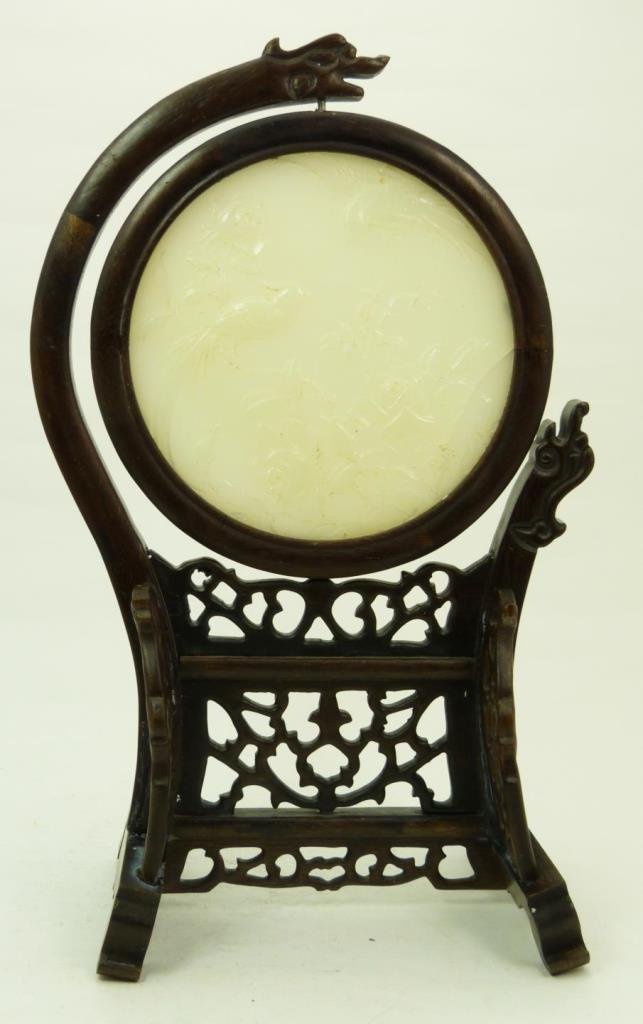 LRG CHINESE CARVED WHITE JADE DISK IN WOODEN STAND: LARGE CHINESE CARVED WHITE JADE DISK IN WOODEN STANDDisk measures 5-1/2" across (13.97cm) x 13" tall (33.02cm) in stand. Wooden stand has dragon head. Late 19th century. Total weight 533g