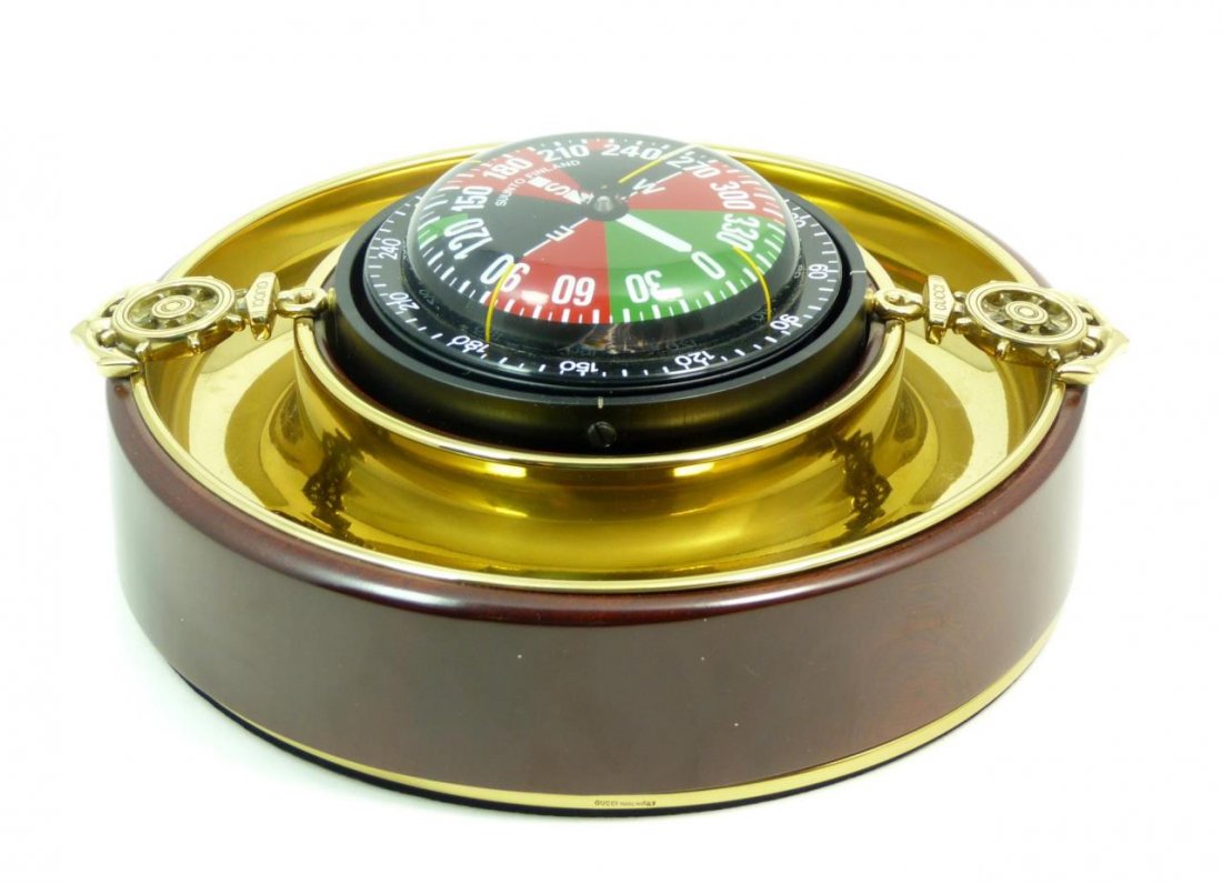 GUCCI DECORATIVE COMPASS: GUCCI DECORATIVE COMPASS Gucci compass made in Finland for Gucci. Heavy brass tray which measures 8' in diameter (20.32cm) with anchors and ships wheels. Signed Gucci. New condition with original box.