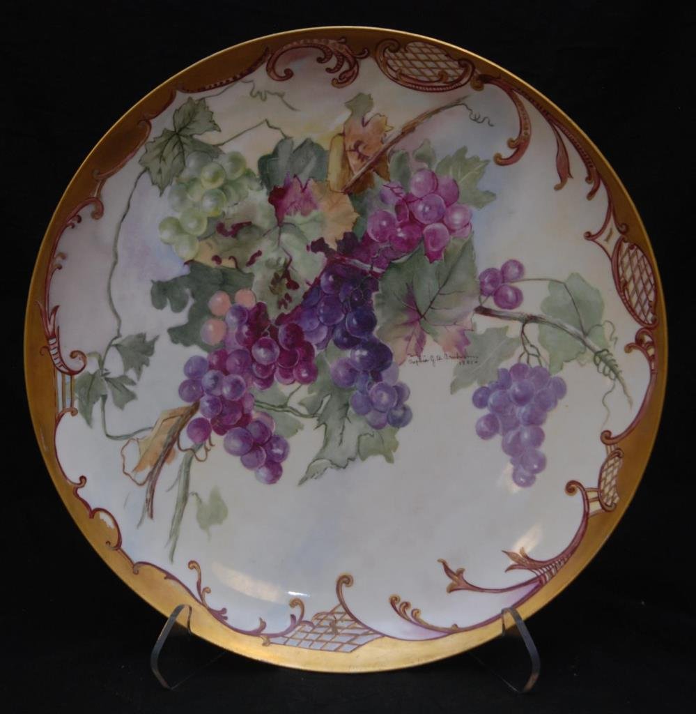 LARGE ANTIQUE HAND PAINTED LIMOGES CHARGER: LARGE ANTIQUE HAND PAINTED LIMOGES CHARGER Hand painted with grapes. Artist signed and dated 1901 with antique gold border. Unmarked to base probably Limoges. Measures 17-1/2" across (44.45cm). Total 