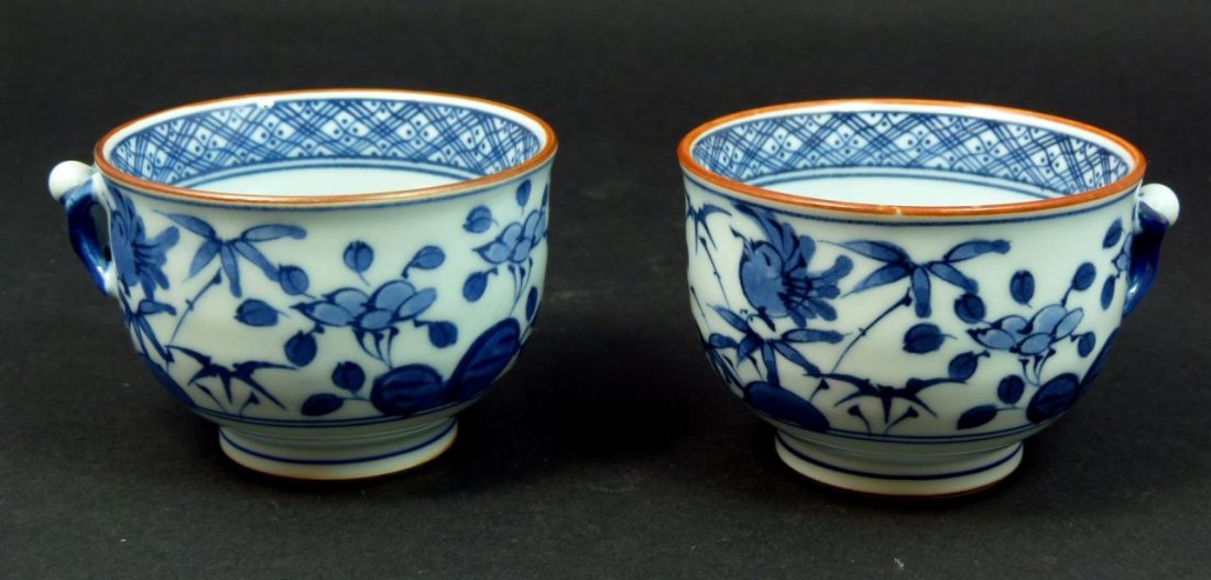 PR OF ANTIQUE CHINESE BLUE & WHITE CUPS: PR OF ANTIQUE CHINESE BLUE & WHITE CUPS Each cup measures 3" in diameter (7.62cm) with handles the shape of a man. Singed in blue to base. Total weight 246g