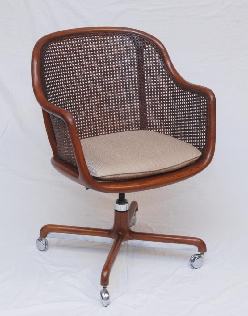WARD BENNETT UPHOLSTER CANE BACK ROLLING CHAIR: WARD BENNETT UPHOLSTER CANE BACK ROLLING CHAIR These chairs are hand made with heavy cane back. Measures 34" tall (86.36cm) x 25" wide (63.50cm).