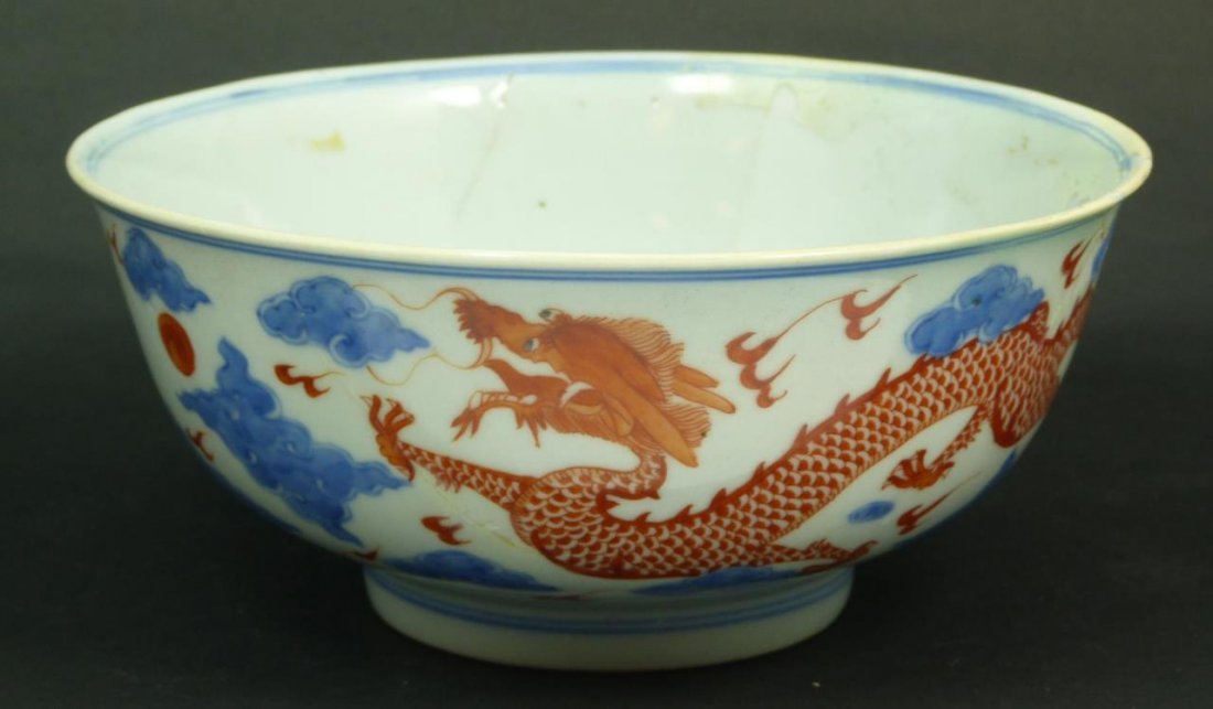 CHINESE IMPERIAL RED & BLUE PORCELAIN DRAGONS BOWL: Antique Chinese hand painted red and blue hand painted porcelain bowl depicting iron red dragons amongst blue lingzhi form clouds. Bottom holds blue six character Qianlong reign mark. Measures approx.