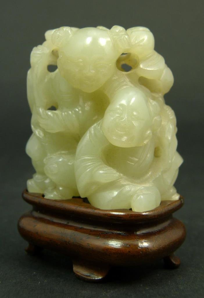 EXQUISITE CHINESE CARVED WHITE HETIAN JADE GROUP: A most beautiful white He-Tian jade sculpture depicting two children with peaches on branch. Set on fitted wooden base. Measures approx. 1 5/8" height + 5/8" height x 1 1/2" width. Jade weight of 46 g