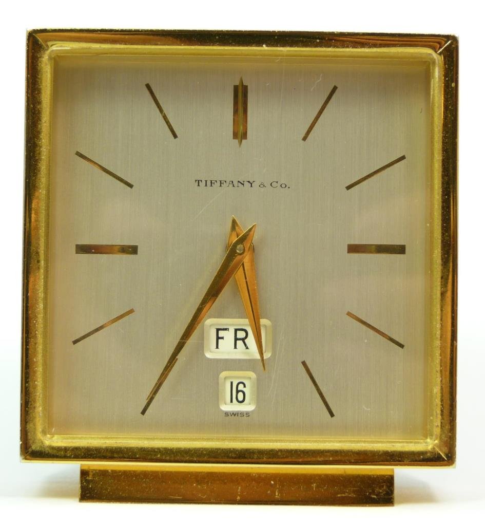 TIFFANY & Co. DAY DATE DECO STYLE DESK CLOCK: Tiffany & Company Deco style desk clock having a day and date design. Gold hour and minute hands with notches over silver face. Gilt metal case with acrylic screen. Swiss 15 jewel Lever Escapement mov