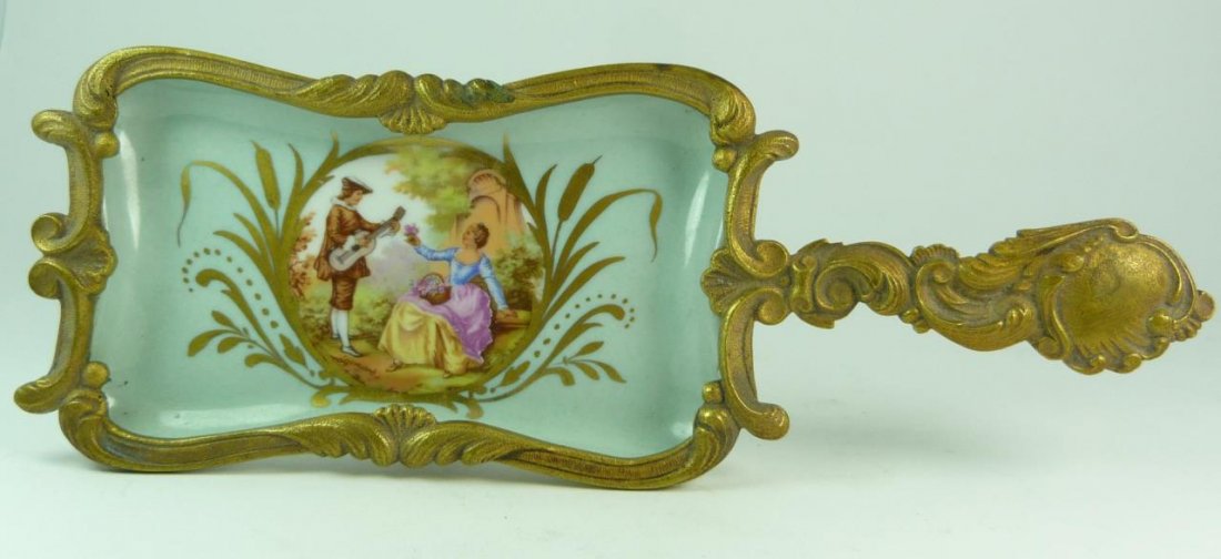 SEVRES H. PAINTED BRONZE & PORCELAIN SILENT BUTLER: Hand painted Sevres porcelain tray in twined in a bronze rococo style handle with colonial figural scene on robins egg blue ground. Signed to base hand painted France with the Sevres mark. Measures 10