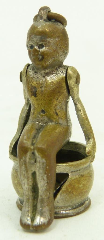ANTIQUE EROTIC BRASS CIGAR CUTTER: Antique erotic brass cigar cutter depicting a naked girl sitting on the pot. Early 20th century. Measures approx 1" (2.54cm) Length. Total approx weight 14g.