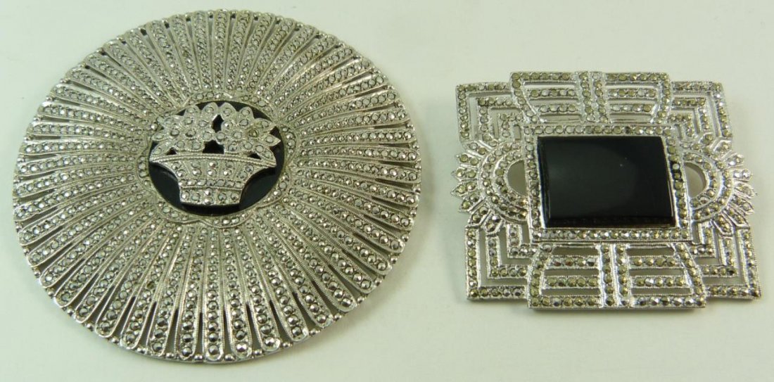 TWO ANTIQUE STERLING & MARCASITE PINS: Two antique sterling silver and marcasite. One being circular with flower pot design that measures 2 1/2" (6.35cm) Diameter. The other being 2" (5.08cm) Length with an onyx center. Total approx weight